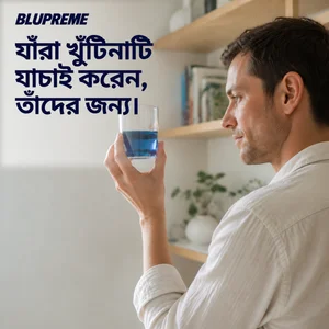 নীল তরলের গ্লাস হাতে একজন ব্যক্তি