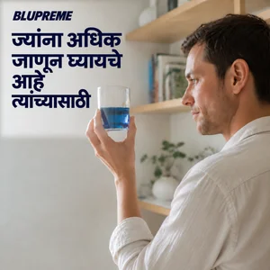 निळ्या द्रवाचा पेला धरलेली व्यक्ती