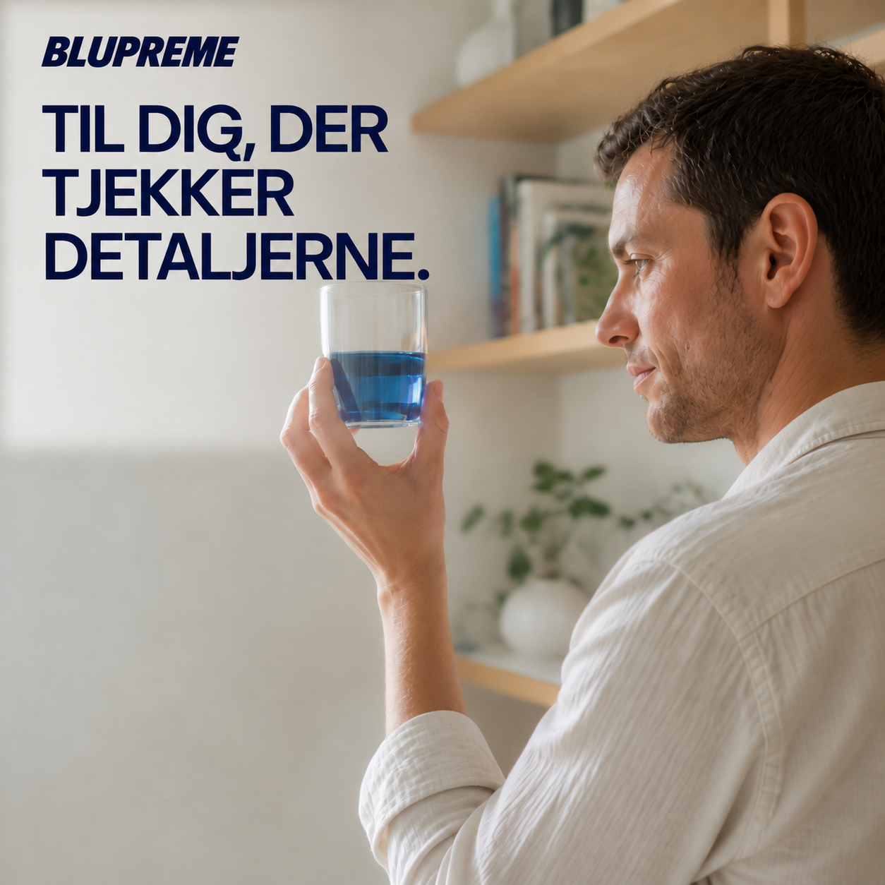 Person, der holder et glas med blå væske
