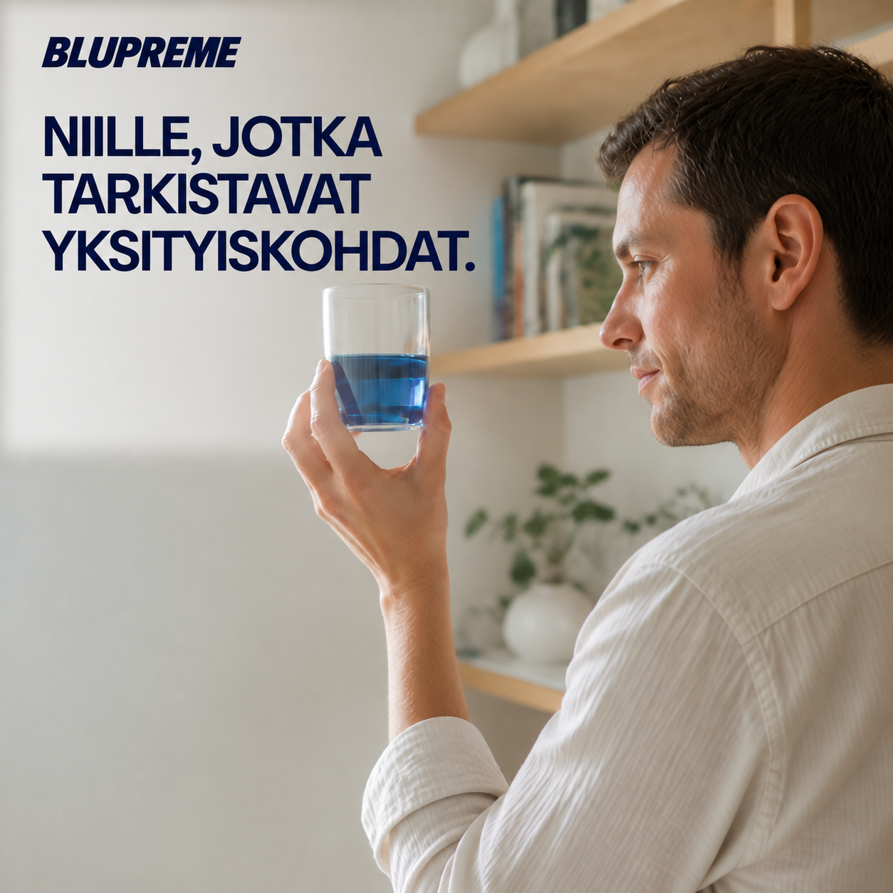Henkilö pitelee lasia, jossa on sinistä nestettä