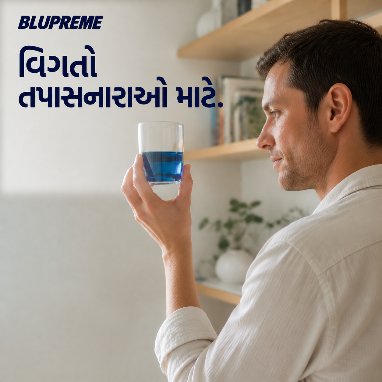 વાદળી પ્રવાહીનો ગ્લાસ પકડી રહેલી વ્યક્તિ