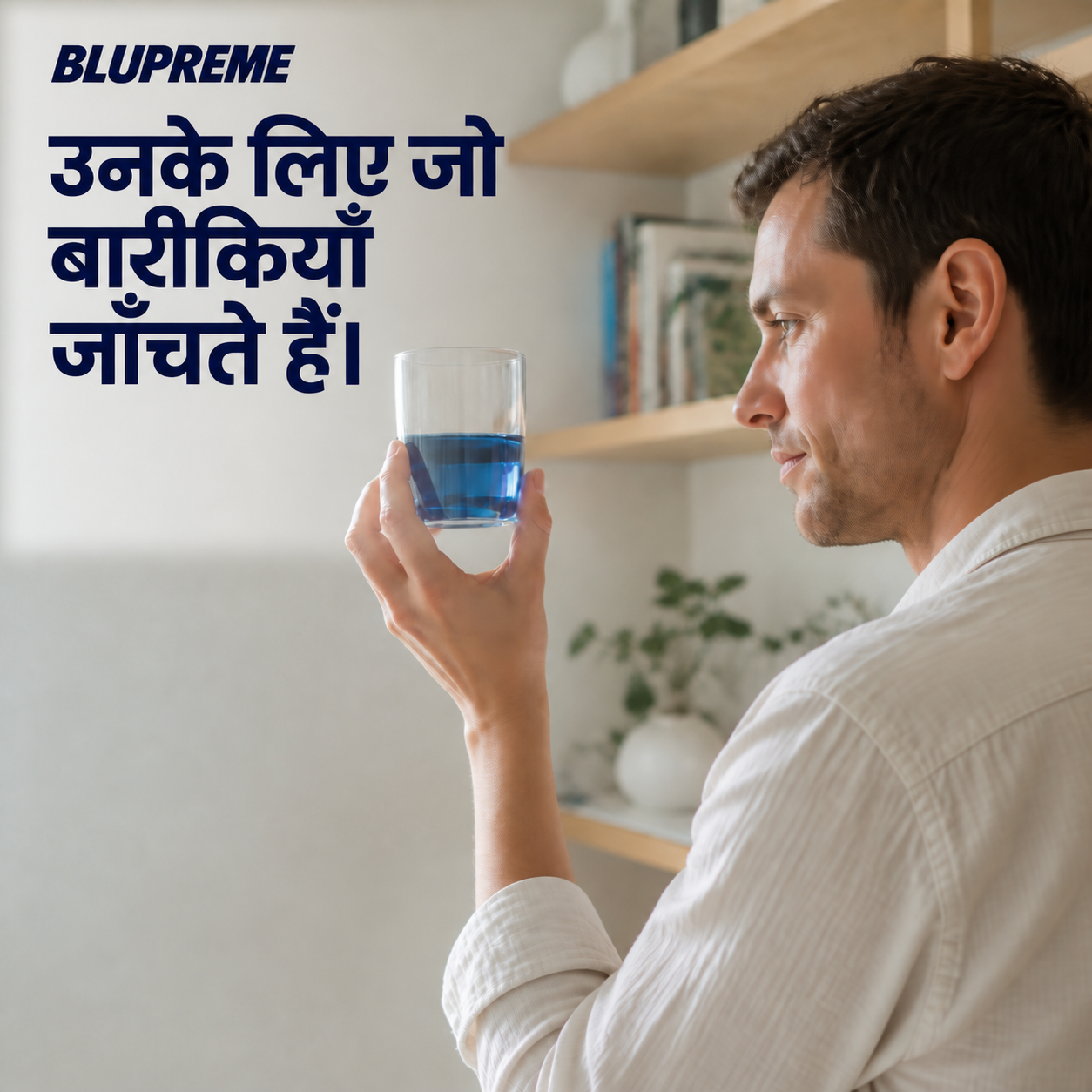 नीले तरल का गिलास पकड़े व्यक्ति