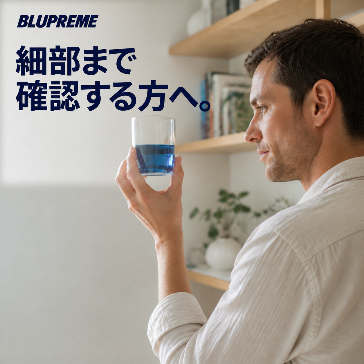 青い液体が入ったグラスを持つ人