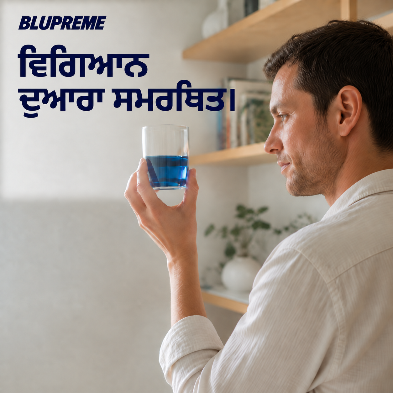 ਨੀਲੇ ਤਰਲ ਦਾ ਗਲਾਸ ਫੜੇ ਹੋਏ ਵਿਅਕਤੀ