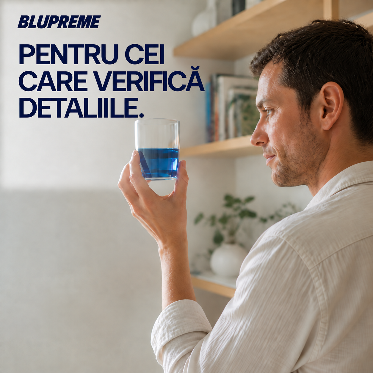 Persoană care ține un pahar cu lichid albastru