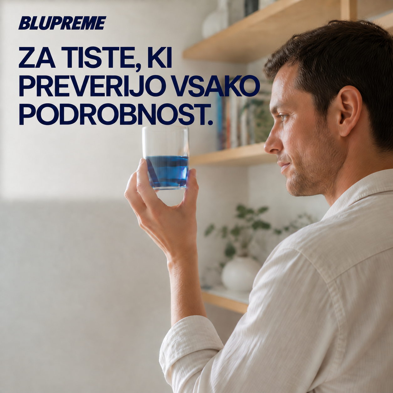 Oseba drži kozarec z modro tekočino