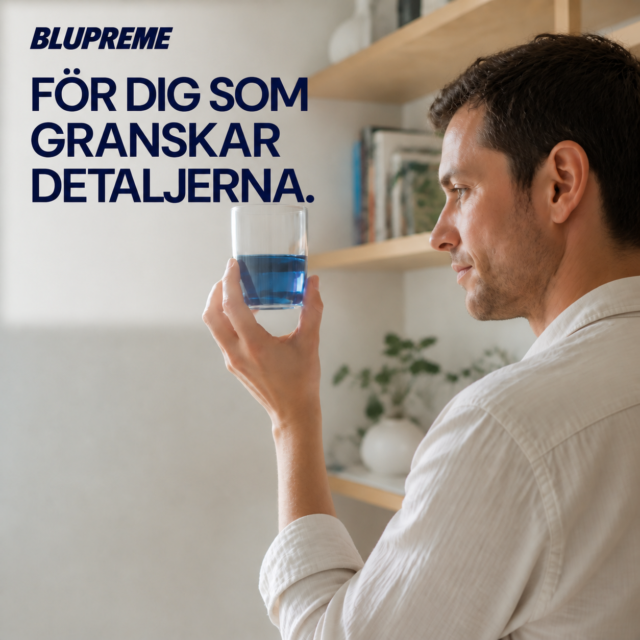 Person som håller ett glas med blå vätska