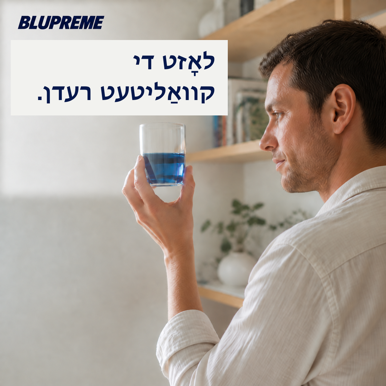 אַ מענטש האַלט אַ גלאָז מיט בלויער פֿליסיקייט